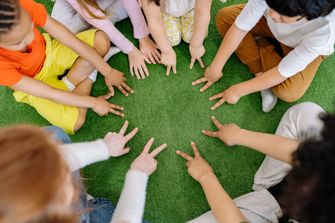 Young children engaged in ABA therapy, using their hands to play with colorful building blocks alongside a therapist in a bright and cheerful learning environment.