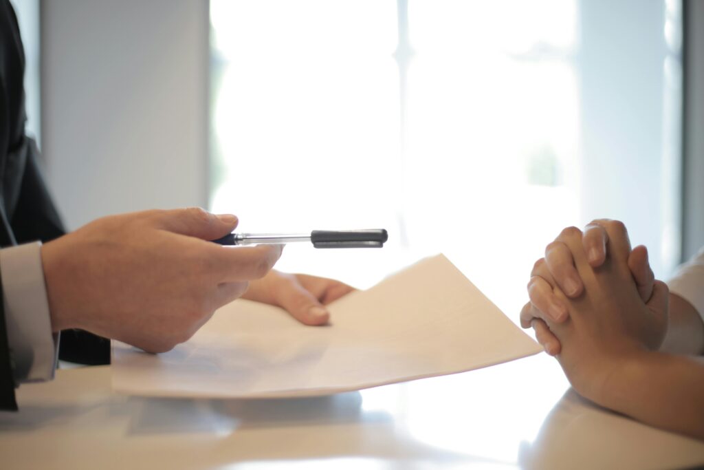 Close-up of a person filling out ABA therapy insurance forms with a pen and paper on a desk, highlighting the documentation process for coverage.