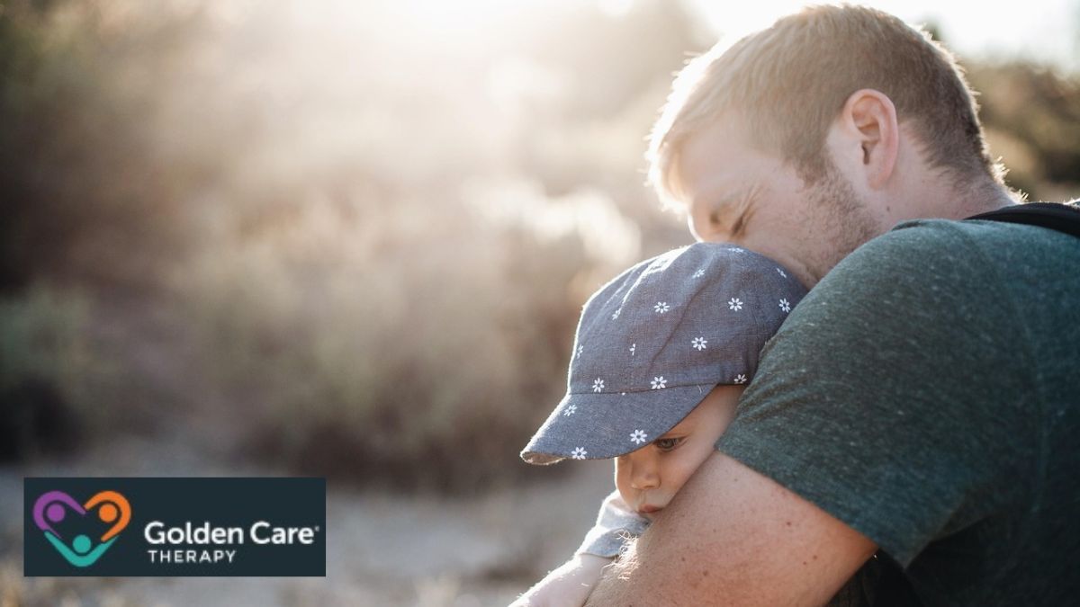 Father hugging his child tightly in the middle of a field, illustrating a moment of connection; topic: autism heredity.