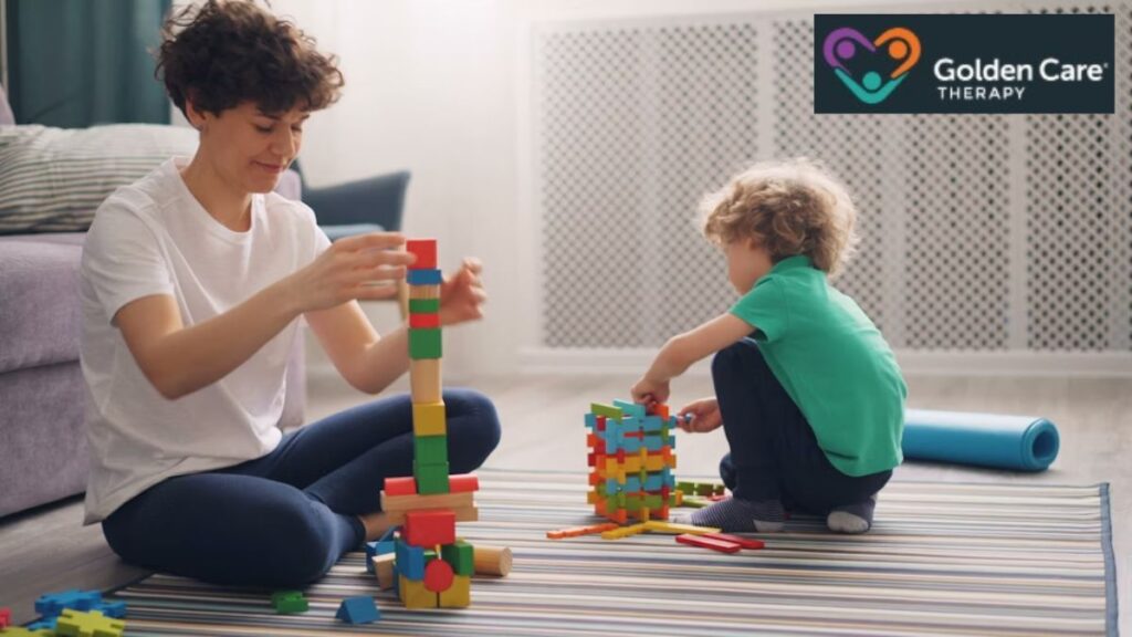 Autism behavioral therapy at home, where an older sibling helps his younger brother build a tower of blocks.