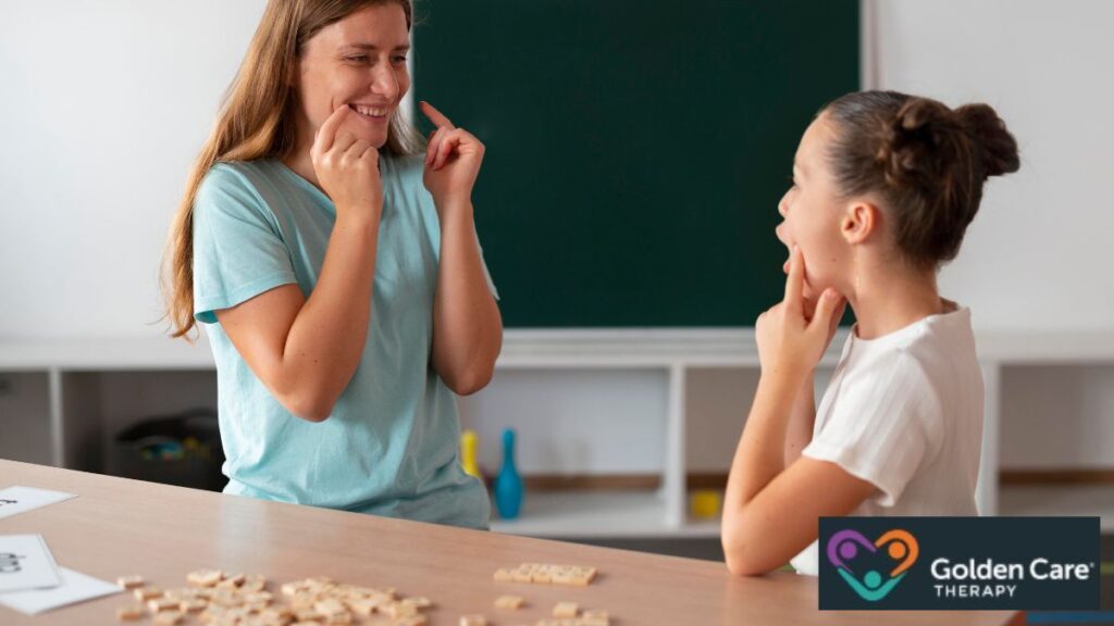 A female therapist demonstrates mouth movements to guide a young girl in autism communication therapy.