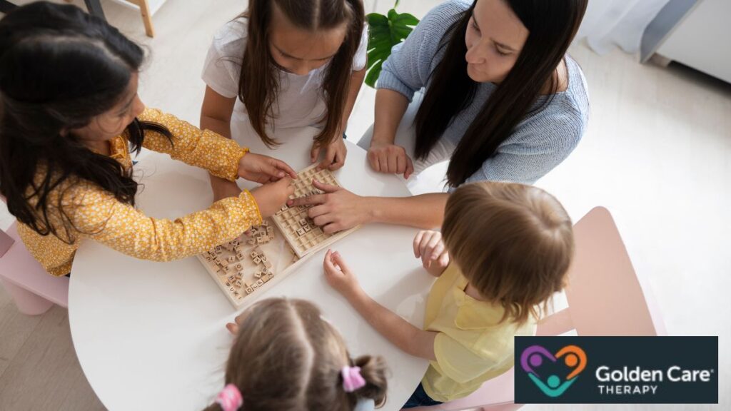 Top-down view of a group of children, including a child with autism, playing with toys on a table, enjoying connection and learning through shared play.