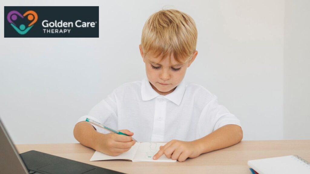 A young boy participates in online ABA therapy, writing in his notepad as he follows an activity instructed by the therapist on the screen.