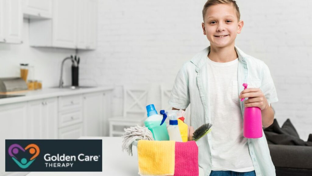 A boy smiles at the camera while holding cleaning products, shown as part of an autism visual-aid activity.